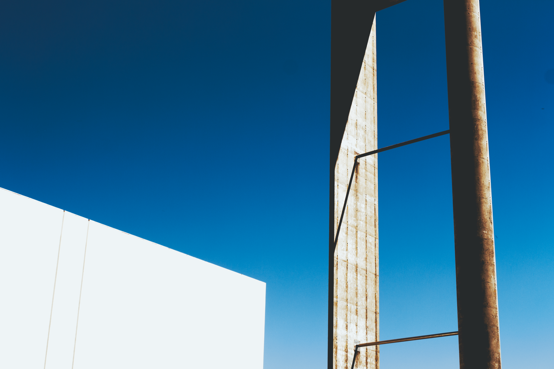 A compelling view of modern architectural design against a vibrant clear blue sky.