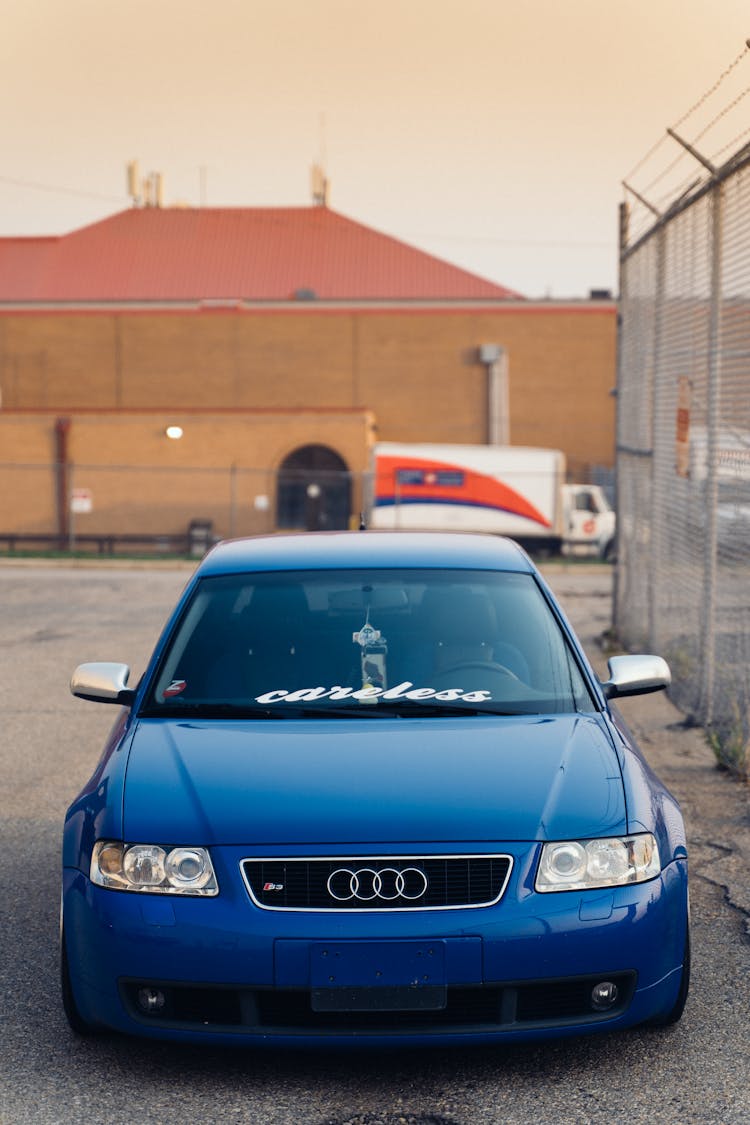 Blue Car Parked Near Chain Link Fence