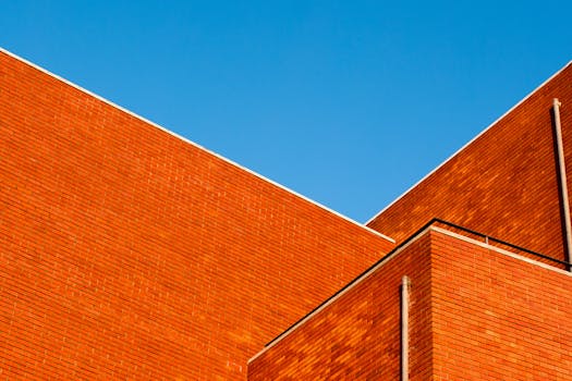 Abstract view of a modern brick building exterior against a clear blue sky.