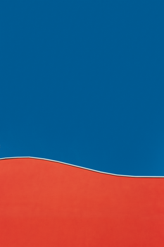 A vibrant abstract design featuring a bold red curve against a deep blue background, showcasing minimalist style.