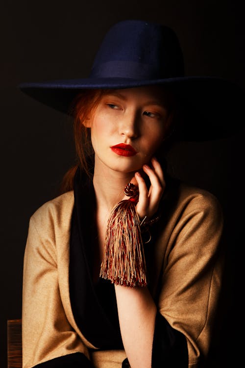 A Beautiful Woman with Red Lips Posing while Holding a Tassel · Free ...