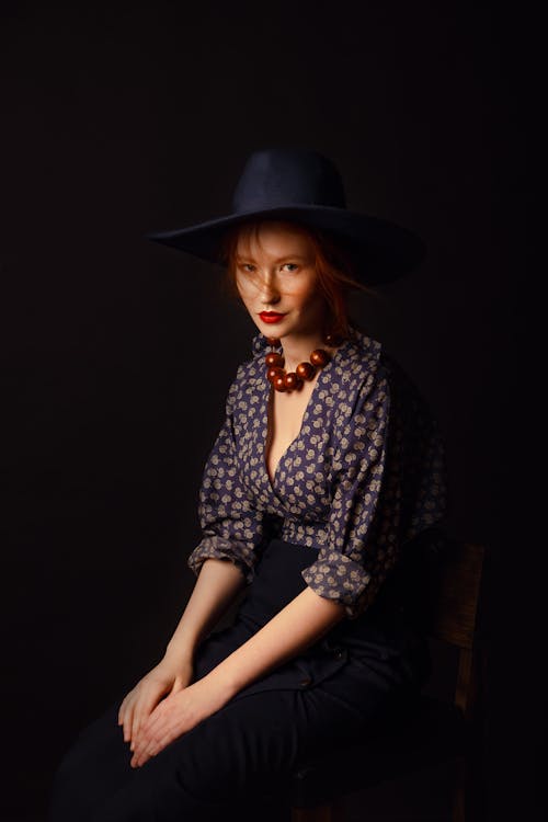 Woman in Printed Long Sleeves Sitting on a Chair