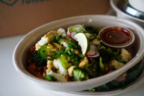Free Colorful vegetable salad bowl with broccoli, cauliflower, jalapeno, and lime in eco-friendly packaging. Stock Photo