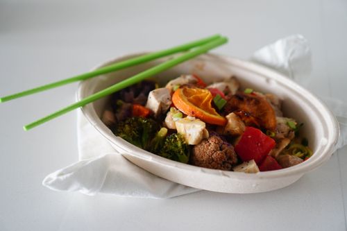 Free A vibrant Asian stir-fry with tofu, vegetables, and citrus in a white bowl. Stock Photo