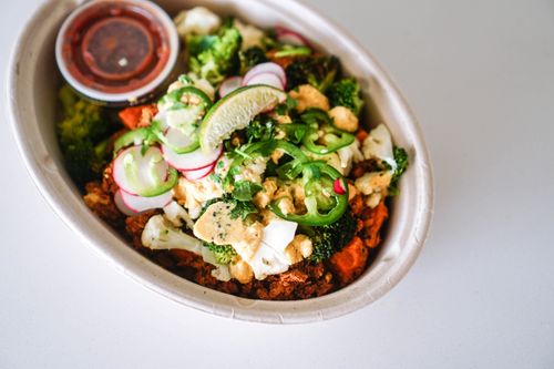 Free Colorful bowl of fresh vegetables with sliced lime, jalapeños, and radishes, showcasing a healthy meal option. Stock Photo