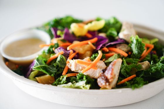 Kale and red cabbage salad with grilled chicken, shredded carrots and vinaigrette cup