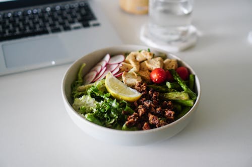 Free A Delicious Bowl of Salad with Walnuts and a Slice of Lemon Stock Photo