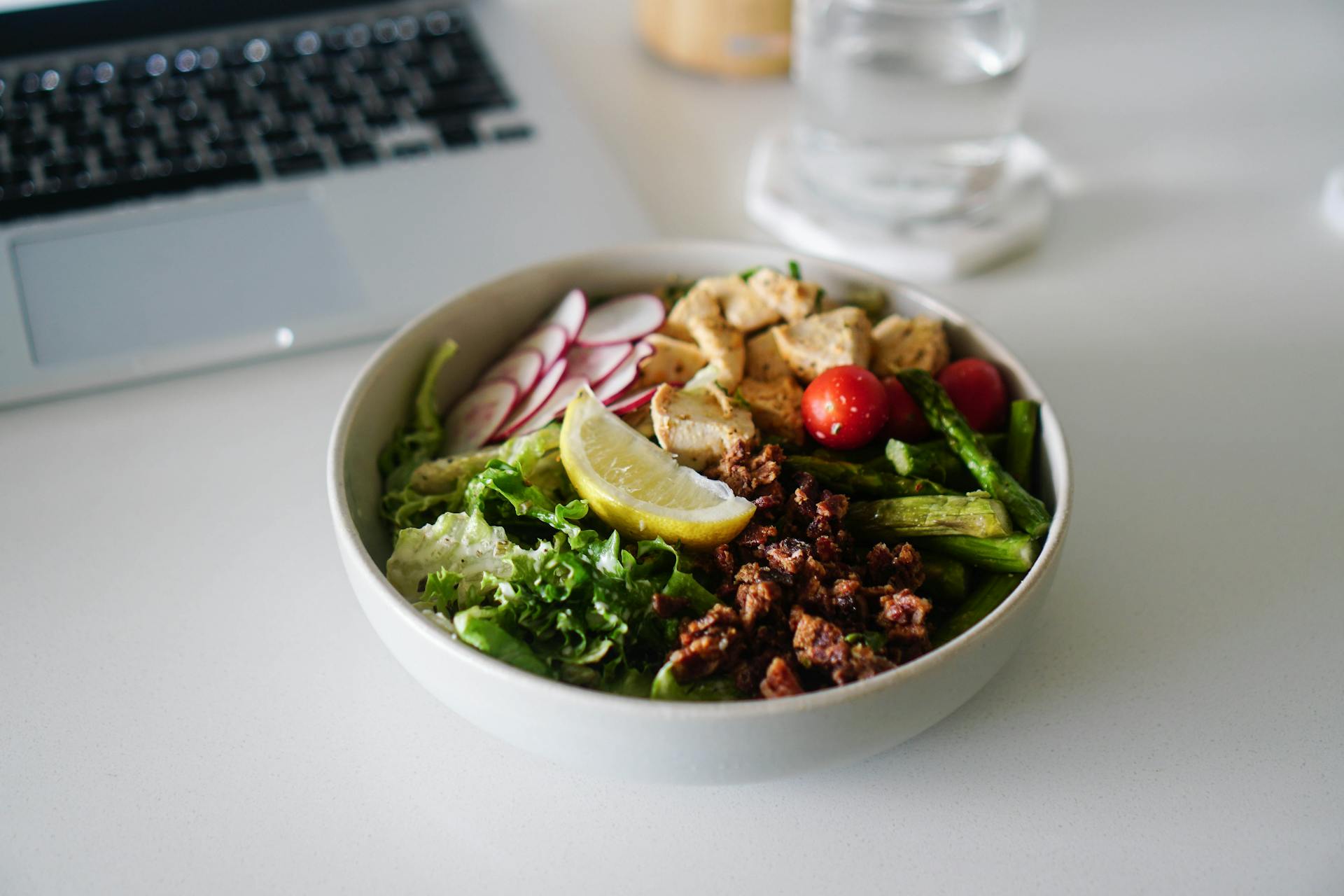 A Delicious Bowl of Salad with Walnuts and a Slice of Lemon