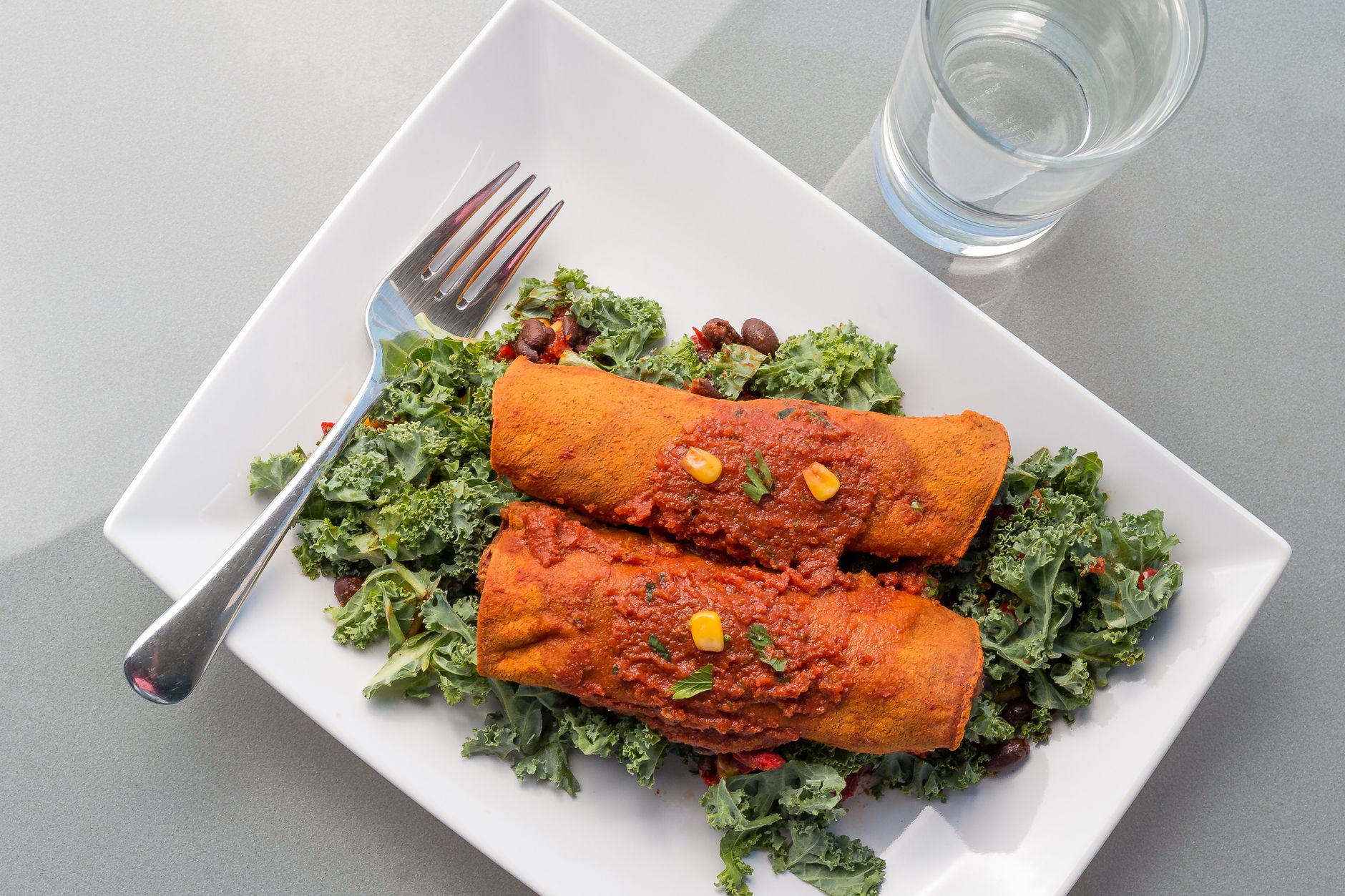 Golden-brown enchiladas covered in vibrant red habanero sauce, topped with melted Monterey Jack cheese, drizzled with Mexican crema, and garnished with fresh cilantro