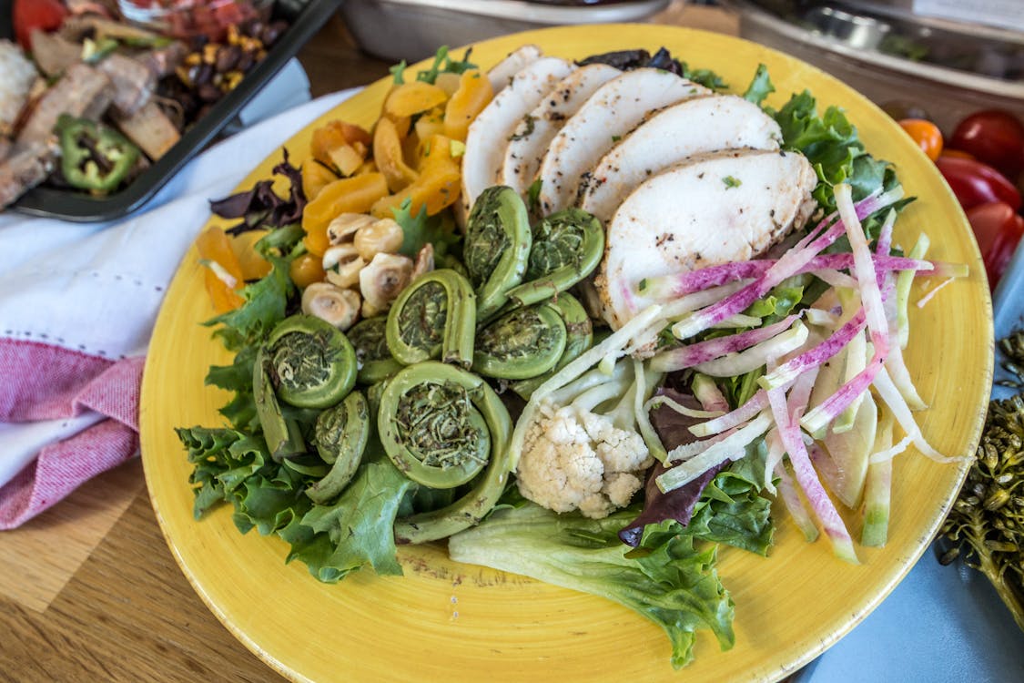 Vegetable Salad with Slices of Meat on a Yellow Ceramic Plate