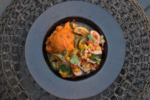Deliciously plated vegetables with sweet potato mash on a textured background.