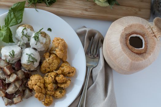 A delicious and nutritious flat lay of cauliflower, potatoes, and coconut on a plate.