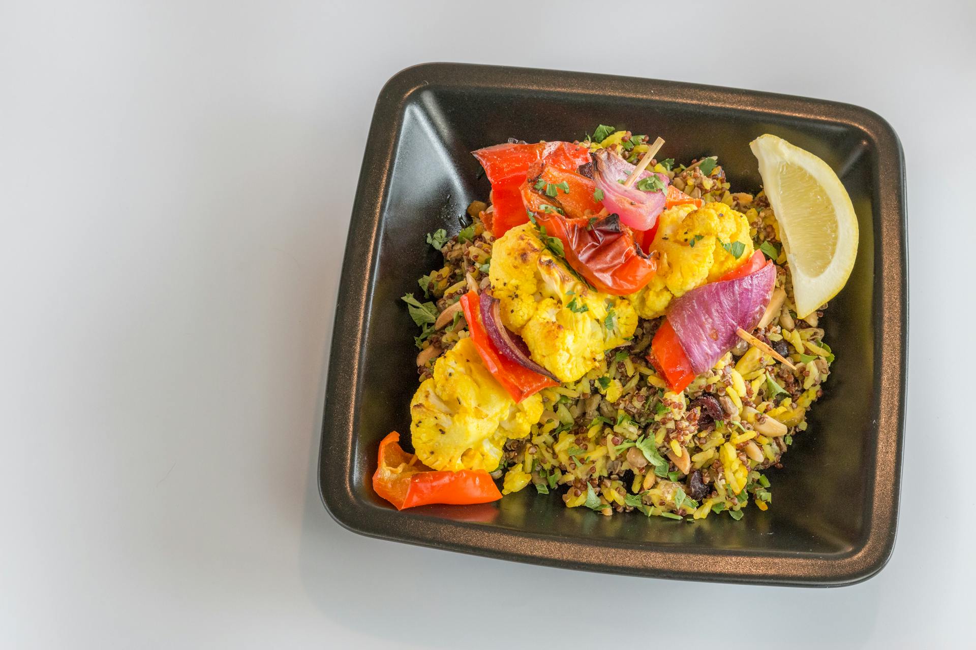 Delicious vegetable biryani with roasted cauliflower kebabs and fresh lemon.