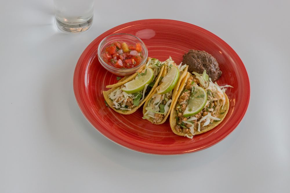 Three filled tortillas on a red plate with a bowl of fresh salsa — Loren Castillo on Pexels
