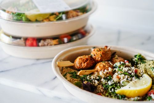 Free Delicious Mediterranean dish with falafel, hummus, and fresh salad in a takeaway bowl. Stock Photo