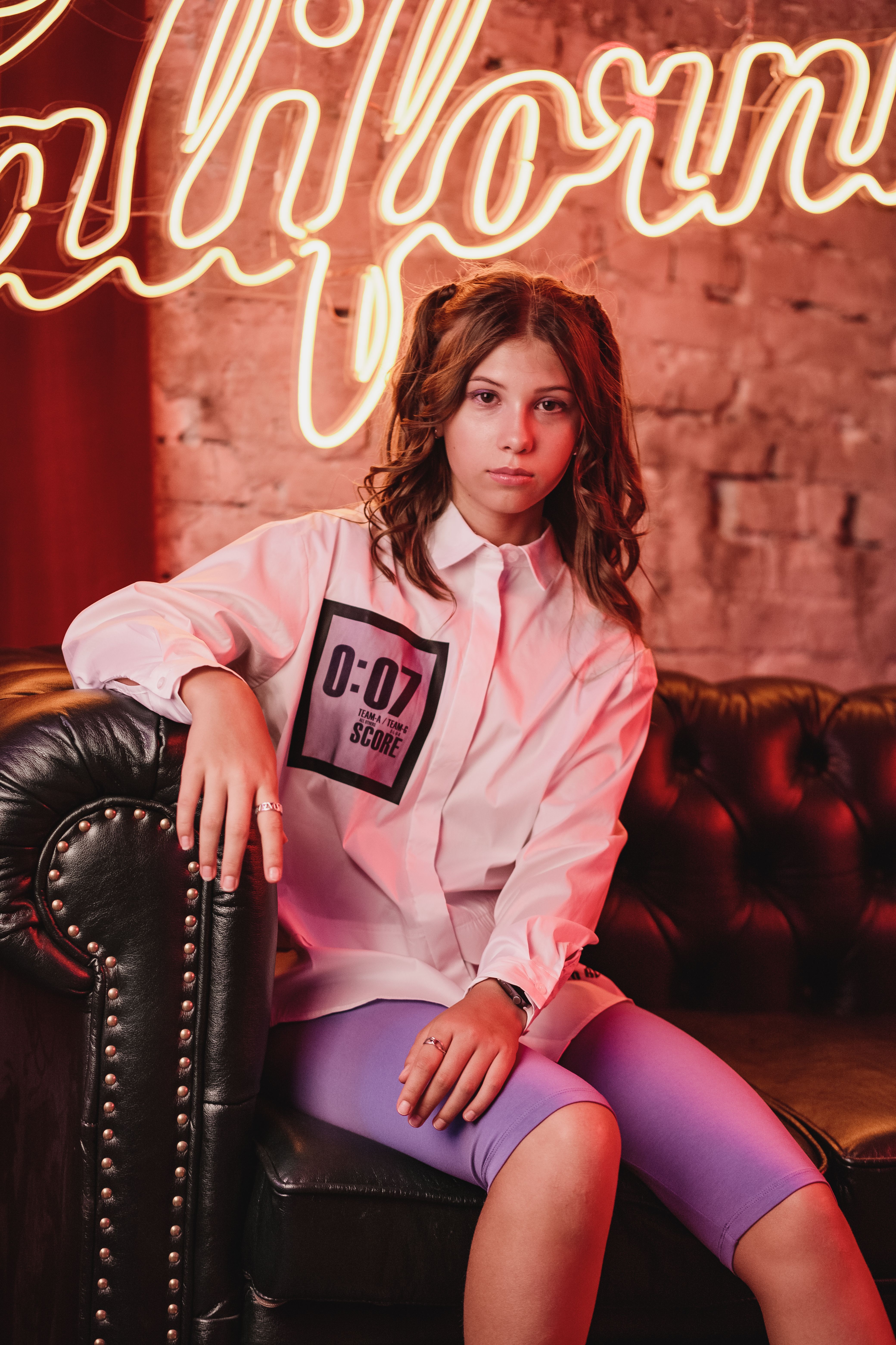A Woman in White Long Sleeves Sitting on a Leather Couch · Free Stock Photo