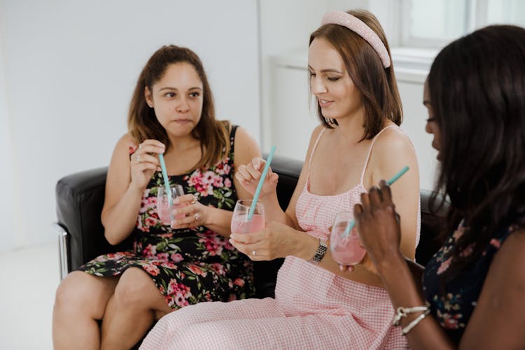 Women Sitting On A Sofa With Drinks