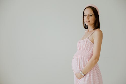 A Pregnant Woman in Pink Spaghetti Strap Dress with Pink Cap