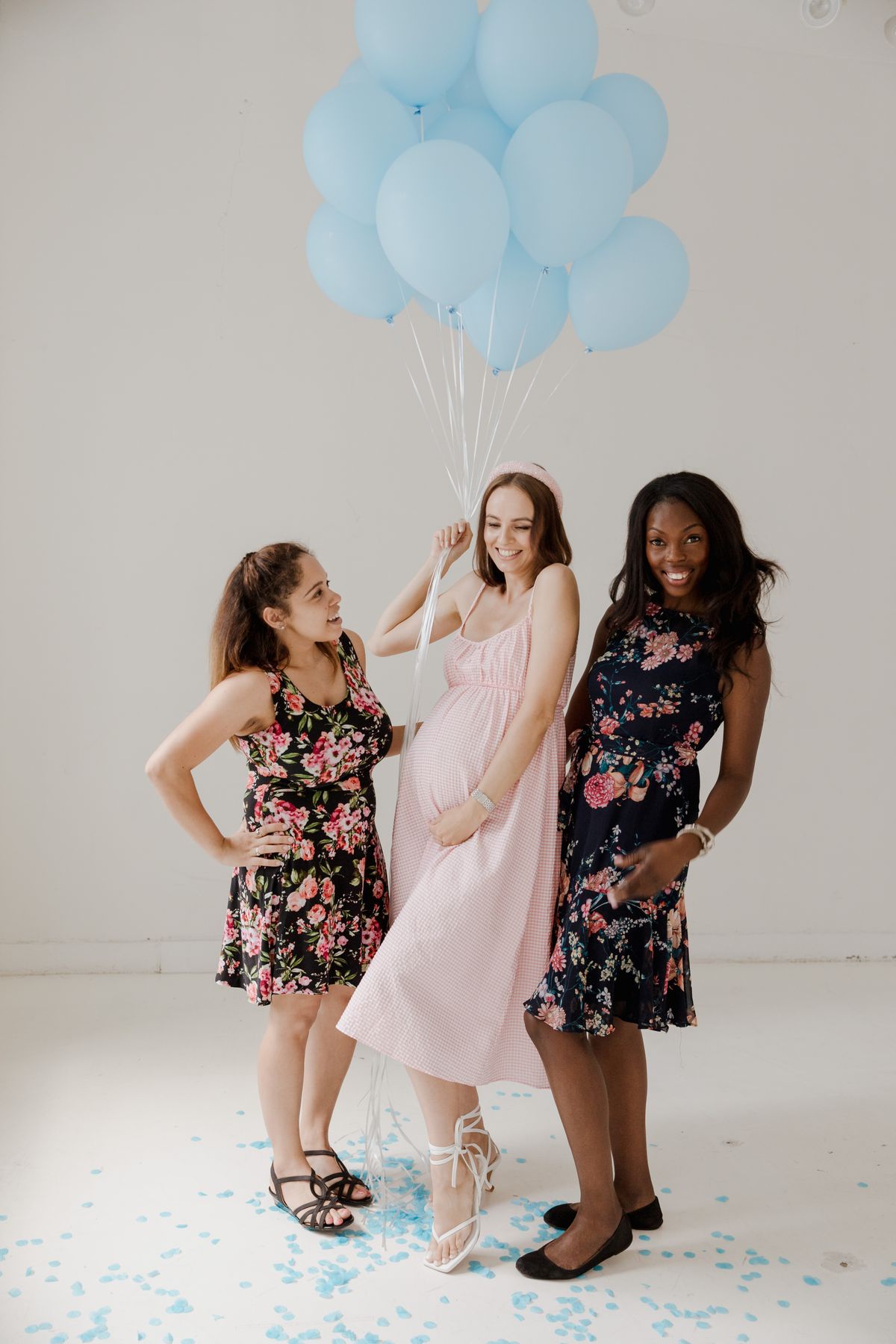 Baby shower photo booth ideas with women celebrating with blue balloons at a baby shower