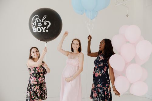 Free Three women celebrate at a gender reveal party with balloons, creating a fun and happy atmosphere. Stock Photo