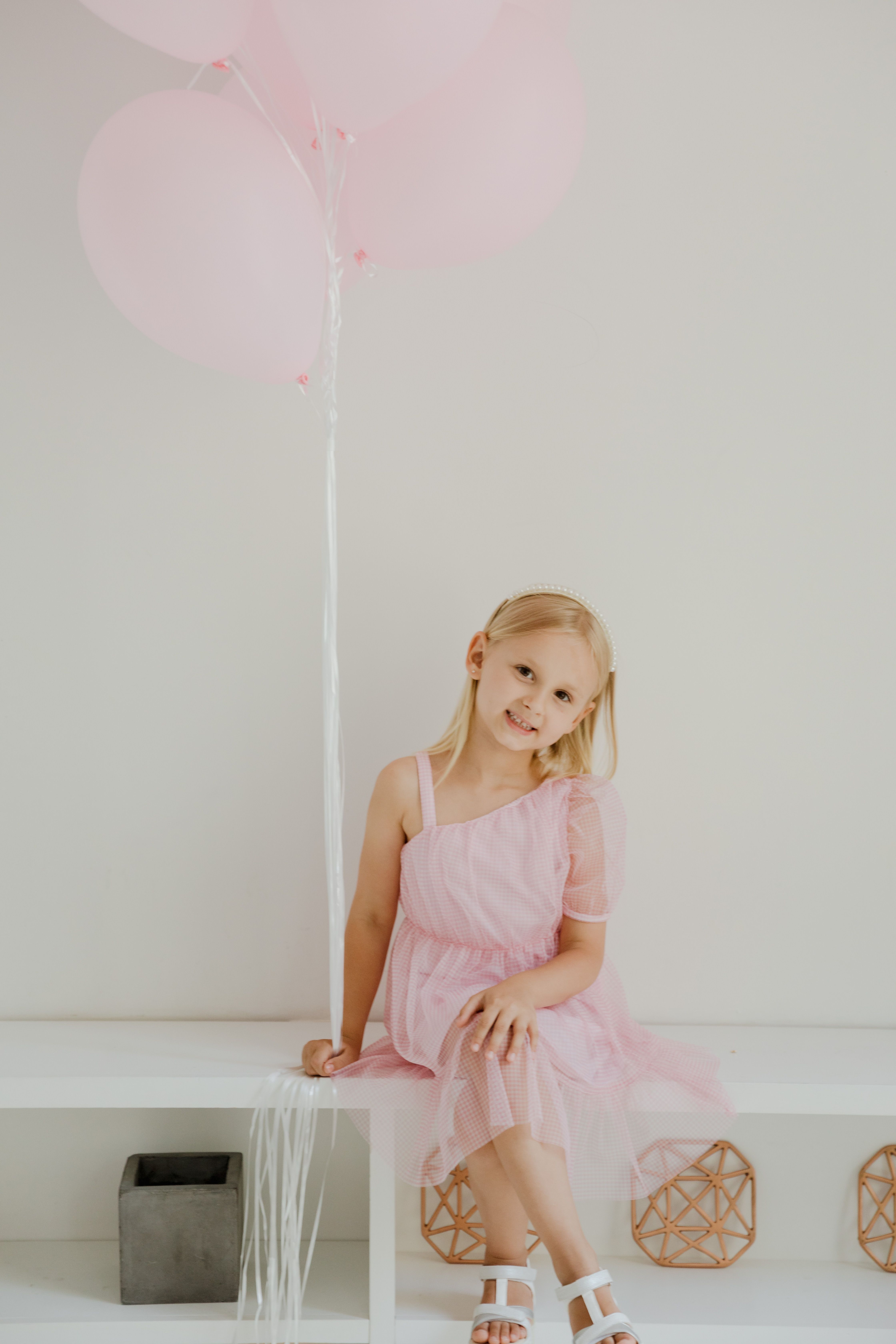 A Girl in Pink Dress Sitting on a White Bench · Free Stock Photo