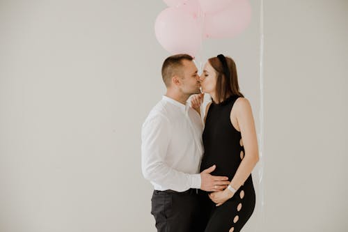 Free A Couple Kissing While Holding the Tummy Stock Photo