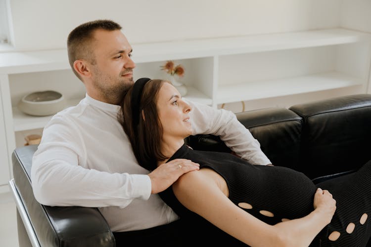 Woman Leaning On A Man While Sitting On A Sofa