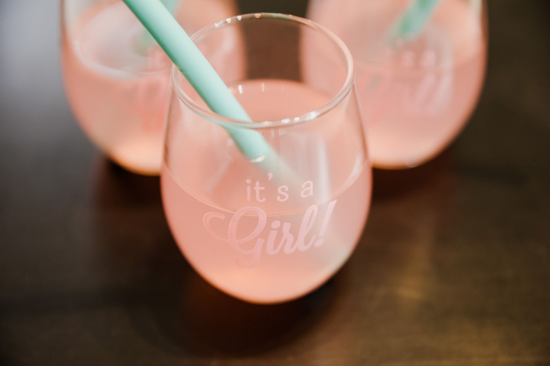 Elegant glasses of pink drink with 'It's a Girl' text perfect for gender reveal celebrations.