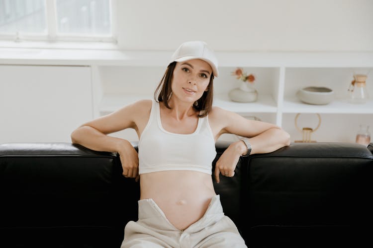 Pregnant Woman Sitting On Sofa At Home