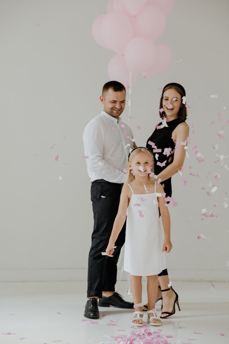 Couple With A Child Holding Balloons