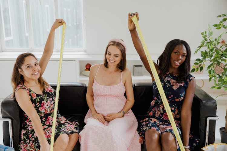 Women Sitting On A Sofa With Measuring Tapes