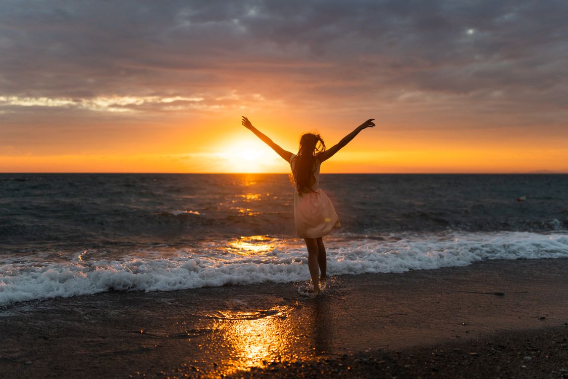 Free A woman joyfully celebrates freedom at sunset on Alakhadzi beach. Stock Photo