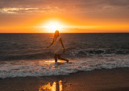 Free A woman in a dress enjoys the tranquil sunset on Alakhadzi beach, creating a serene vacation vibe. Stock Photo
