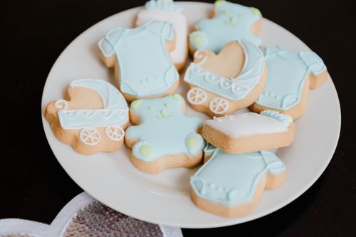 Free Decorative cookies themed for a baby shower featuring strollers and onesies in pastel blues. Stock Photo