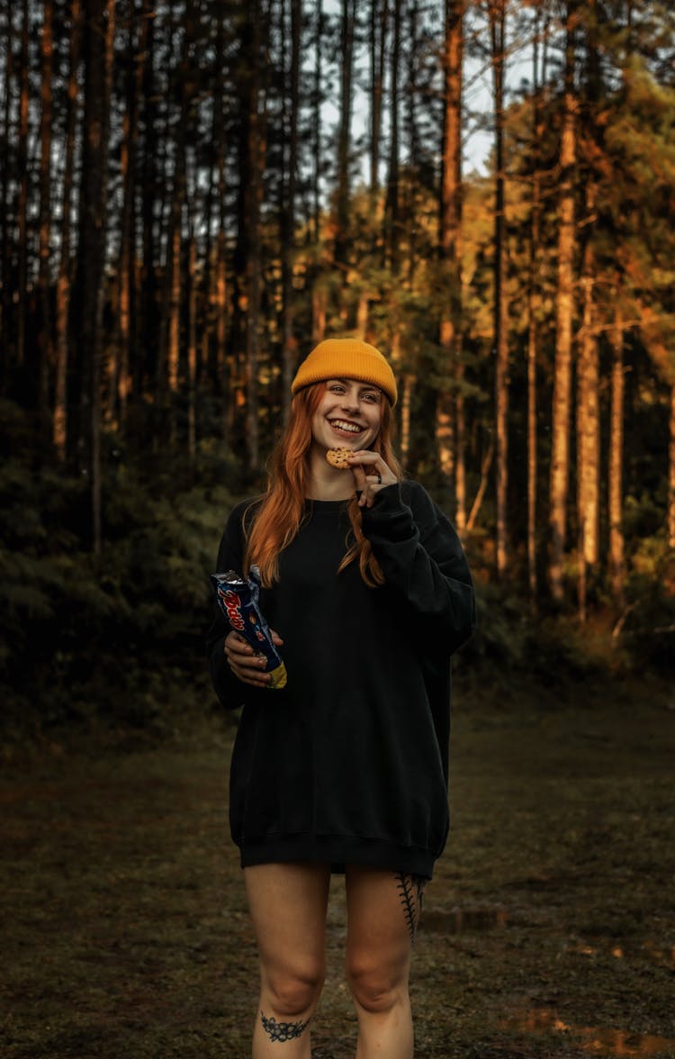 Happy Woman In Black Sweater Eating Cookies