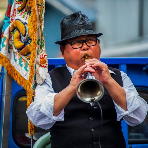 Free Musician wearing a fedora plays the trumpet in a vibrant street setting in Luodong, Taiwan. Stock Photo