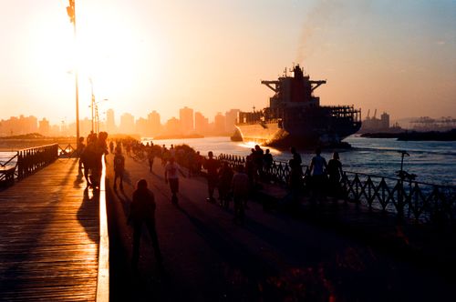 Free Silhouetted people and ship in Brazilian harbor during sunset, creating a vibrant skyline view. Stock Photo