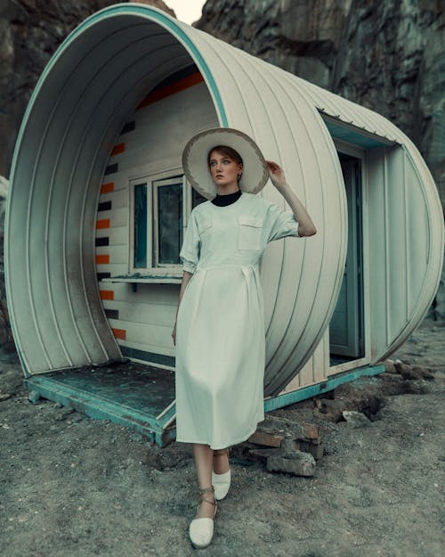 Woman in Dress Standing by Futuristic Capsule Like Cabin