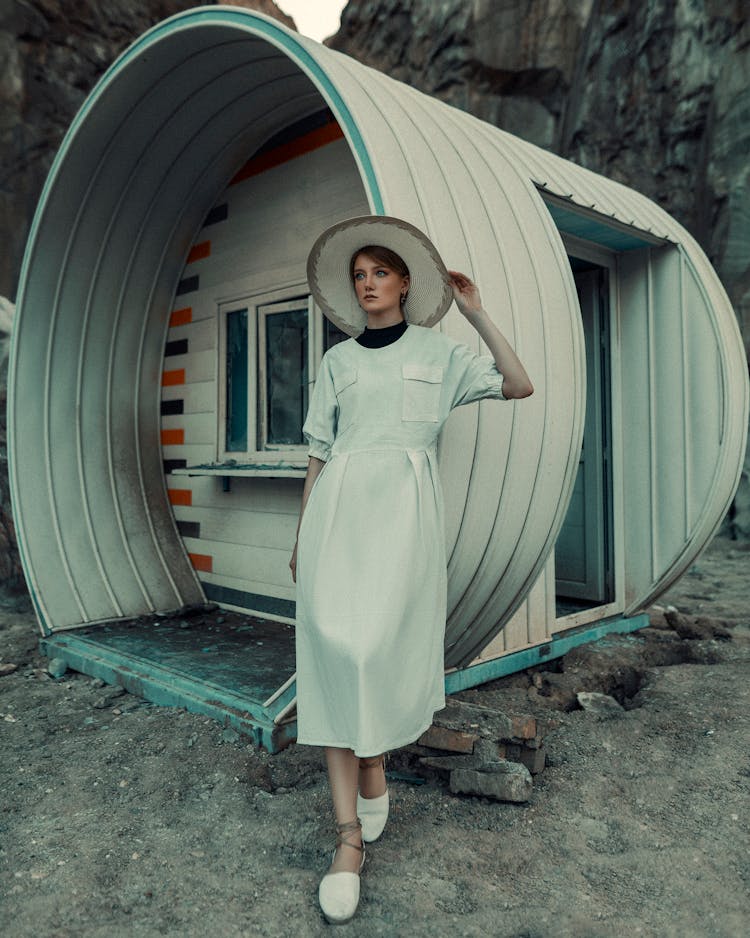 Woman In Dress Standing By Futuristic Capsule Like Cabin