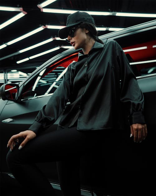 A Woman Wearing Black Clothes Standing Beside the Car
