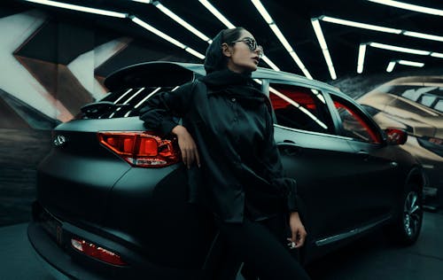 Free Woman Wearing a Black Long Sleeves Leaning on a Vehicle Stock Photo