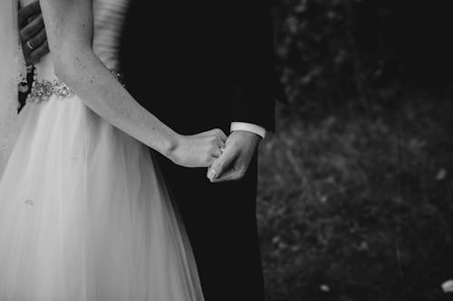 Bride and Groom Holding Hands and Embracing 