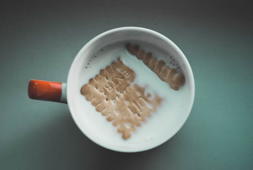 White Mug Filled White With Milk and Brown Biscuit