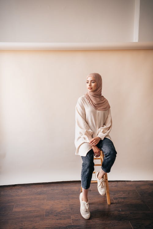 Woman in Beige Hijab Looking Away while Sitting