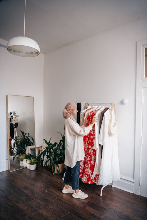 A Woman Looking at the Clothes on a Clothes Rack