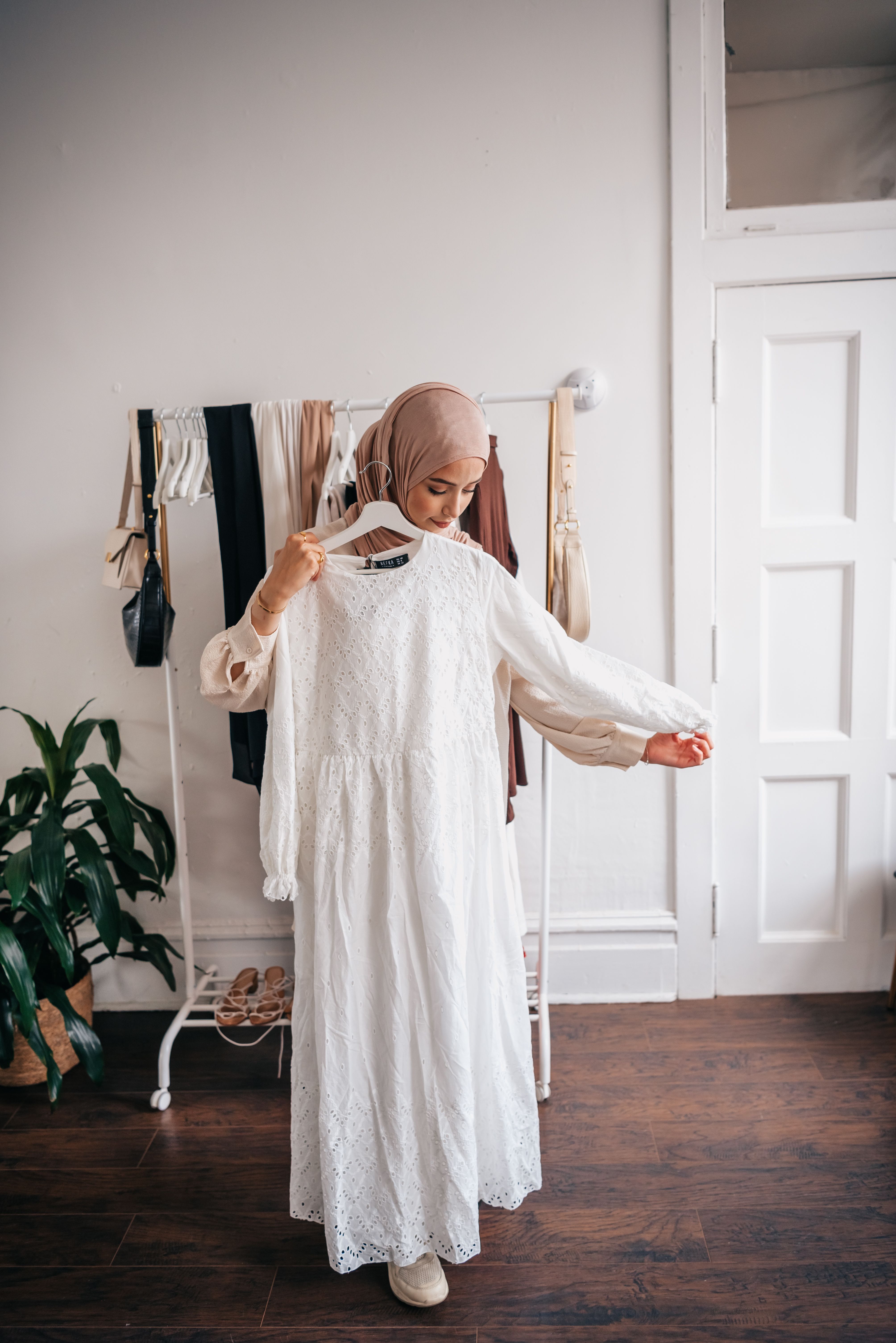 Woman in Brown Hijab Holding White Dress · Free Stock Photo
