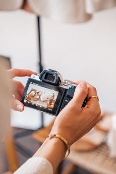 Hands holding a camera capturing a still life composition with warm tones.