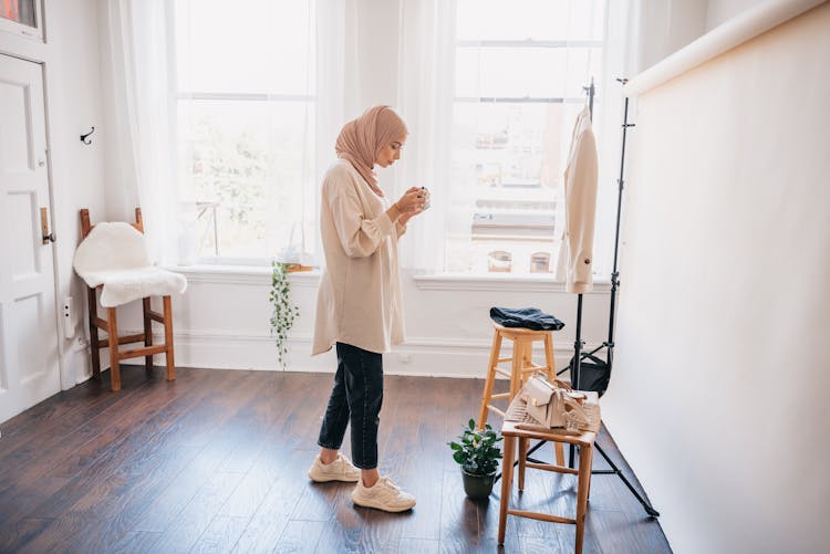 Woman Taking Photos Of Clothes And Accessories In An Apartment 