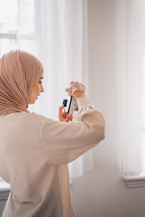 Free Woman Wearing Hijab Taking Photo with a Camera Stock Photo