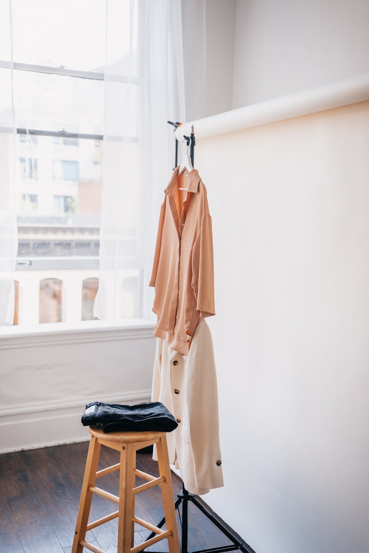 Photo Of Clothes Hanging Near A Wooden Stool